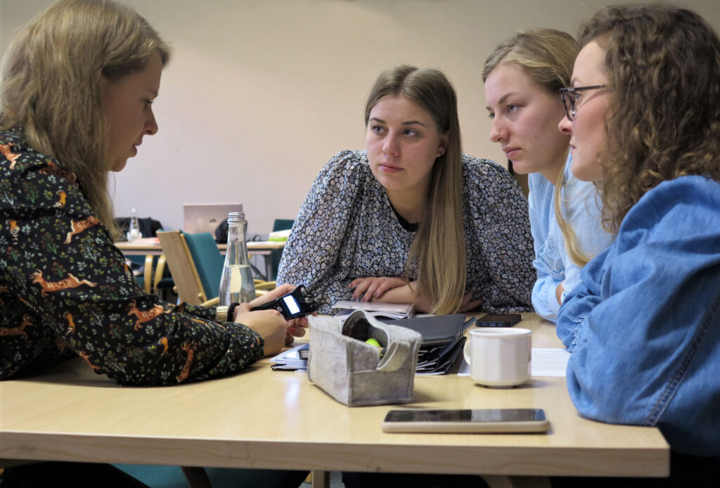 Cztery młode kobiety rozmawiają podczas warsztatów o nagrywaniu historii mówionej.