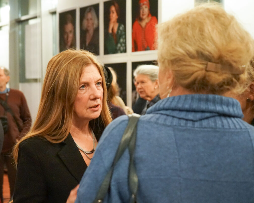 Goście wystawy oglądają fotografie portretowe ukraińskich kobiet prezentowane w sali.